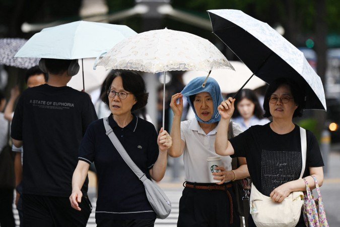 Em Seul, pessoas tentam se proteger das altas temperatura com sombrinhas: alerta é que o calor pode aumentar - (crédito: AFP) Em Seul, pessoas tentam se proteger das altas temperatura com sombrinhas: alerta é que o calor pode aumentar - (crédito: AFP)
