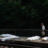 Homem caminha diante de corpos armazenados em sacos mortuários, em estação ferroviária de Kiev: civis na linha de fogo dos bombardeios -  (crédito: Mykola Tymchenko/AFP))