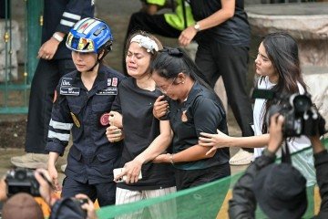 Estudantes e familiares buscam abrigo e conforto em frente à escola Debsirin, na província de Nonthaburi, após o ataque - (crédito: Lillian Suwanrumpha/AFP) Estudantes e familiares buscam abrigo e conforto em frente à escola Debsirin, na província de Nonthaburi, após o ataque - (crédito: Lillian Suwanrumpha/AFP)
