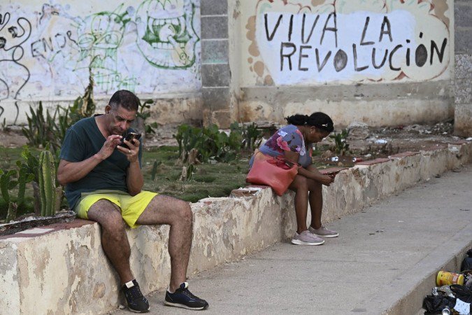 Diante de mural que exalta a revolução, cidadãos aproveitam 