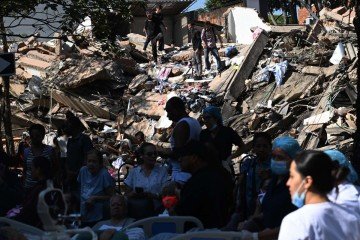 Pessoas buscam sobreviventes em meio aos escombros de um prédio que desabou após um terremoto em Cali, na Colômbia, em 10 de agosto de 2026       -  (crédito: JOAQUIN SARMIENTO / AFP)
