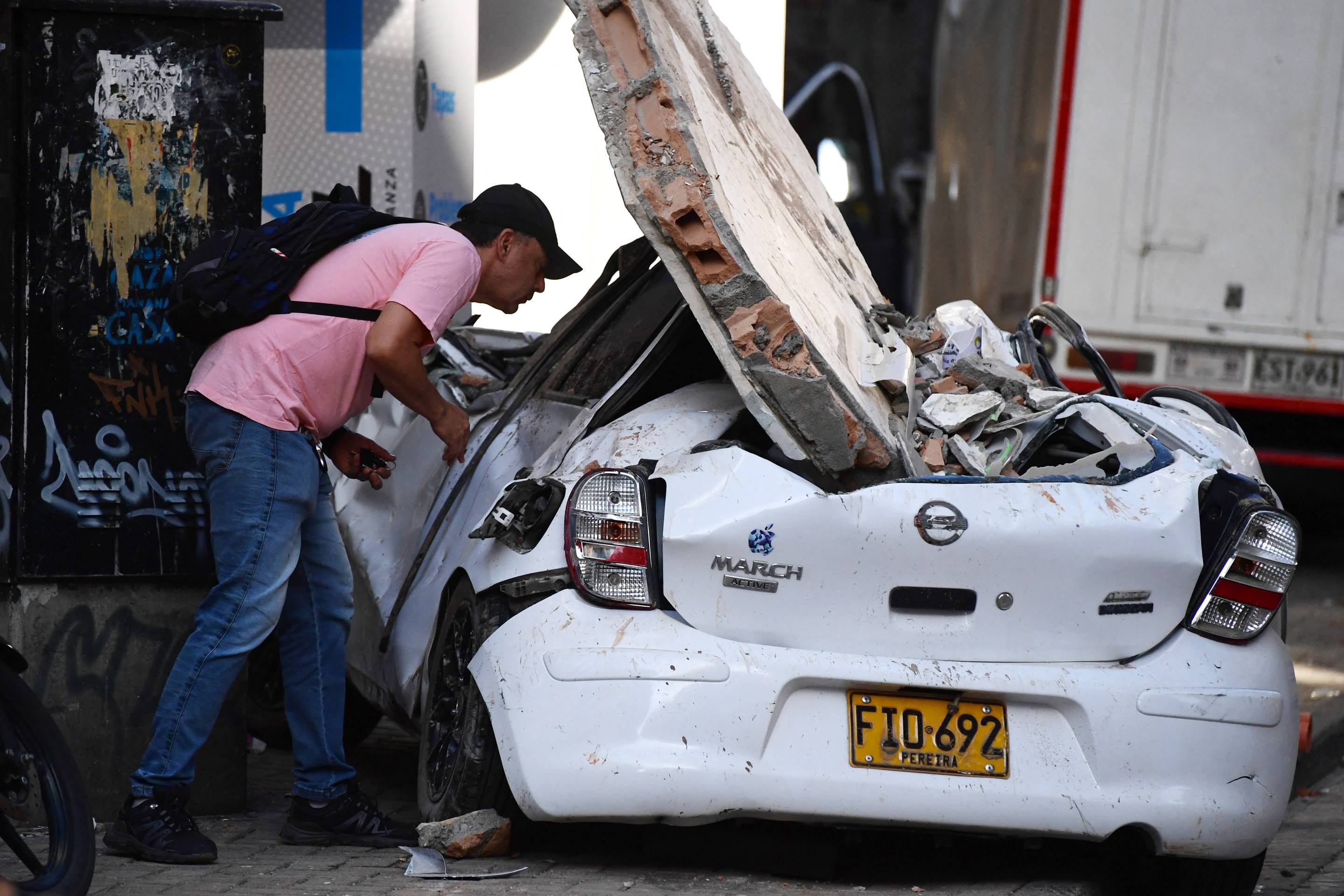 Homem olha dentro de carro danificado por placa de concreto, tamb&eacute;m em Pereira 