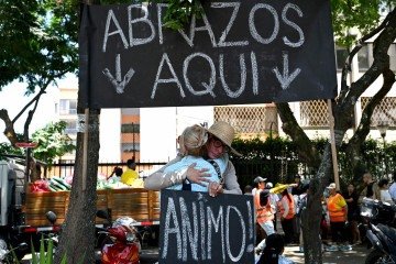 Pessoas trocam afeto em uma 'cabine de abraços', três dias depois do terremoto de magniude 7.4, em Cali - (crédito: Raul Arboleda/AFP) Pessoas trocam afeto em uma 'cabine de abraços', três dias depois do terremoto de magniude 7.4, em Cali - (crédito: Raul Arboleda/AFP)
