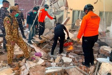 This handout picture taken and released on August 15, 2026 by Indonesia's National Search and Rescue Agency (BASARNAS) shows rescuers working amid the rubble of a damaged building after an earthquake in Maumere, East Nusa Tenggara. A powerful 7.7-magnitude earthquake struck off Flores island in eastern Indonesia early on August 15, killing at least two and sending thousands running in panic after authorities issued a tsunami warning. (Photo by Handout / INDONESIA'S NATIONAL SEARCH AND RESCUE AGENCY (BASARNAS) / AFP) / RESTRICTED TO EDITORIAL USE - MANDATORY CREDIT 'AFP PHOTO / SOURCE / BYLINE' - HANDOUT - NO MARKETING NO ADVERTISING CAMPAIGNS - DISTRIBUTED AS A SERVICE TO CLIENTS
Caption - (crédito: Handout/Indonesia's National Search and Rescue Agency (Basarnas)/AFP) This handout picture taken and released on August 15, 2026 by Indonesia's National Search and Rescue Agency (BASARNAS) shows rescuers working amid the rubble of a damaged building after an earthquake in Maumere, East Nusa Tenggara. A powerful 7.7-magnitude earthquake struck off Flores island in eastern Indonesia early on August 15, killing at least two and sending thousands running in panic after authorities issued a tsunami warning. (Photo by Handout / INDONESIA'S NATIONAL SEARCH AND RESCUE AGENCY (BASARNAS) / AFP) / RESTRICTED TO EDITORIAL USE - MANDATORY CREDIT 'AFP PHOTO / SOURCE / BYLINE' - HANDOUT - NO MARKETING NO ADVERTISING CAMPAIGNS - DISTRIBUTED AS A SERVICE TO CLIENTS
Caption - (crédito: Handout/Indonesia's National Search and Rescue Agency (Basarnas)/AFP)