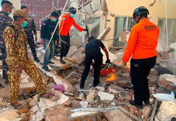  This handout picture taken and released on August 15, 2026 by Indonesia's National Search and Rescue Agency (BASARNAS) shows rescuers working amid the rubble of a damaged building after an earthquake in Maumere, East Nusa Tenggara. A powerful 7.7-magnitude earthquake struck off Flores island in eastern Indonesia early on August 15, killing at least two and sending thousands running in panic after authorities issued a tsunami warning. (Photo by Handout / INDONESIA'S NATIONAL SEARCH AND RESCUE AGENCY (BASARNAS) / AFP) / RESTRICTED TO EDITORIAL USE - MANDATORY CREDIT 'AFP PHOTO /  SOURCE / BYLINE' - HANDOUT - NO MARKETING NO ADVERTISING CAMPAIGNS - DISTRIBUTED AS A SERVICE TO CLIENTS
      Caption  -  (crédito: Handout/Indonesia's National Search and Rescue Agency (Basarnas)/AFP)