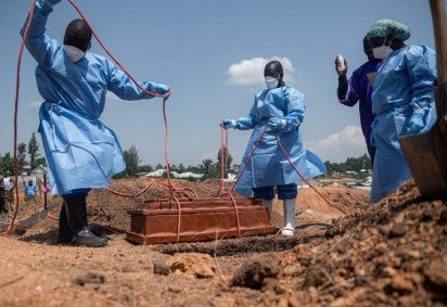 Equipes da Cruz Vermelha e do Crescente Vermelho preparam, no cemitério de Mbiyo, o sepultamento do corpo de um quarto órfão que morreu vítima da doença causada pelo vírus Ebola em um orfanato  -  (crédito: Jospin Mwisha/AFP) -Equipes da Cruz Vermelha e do Crescente Vermelho preparam, no cemitério de Mbiyo, o sepultamento do corpo de um quarto órfão que morreu vítima da doença causada pelo vírus Ebola em um orfanato  -  (crédito: Jospin Mwisha/AFP)