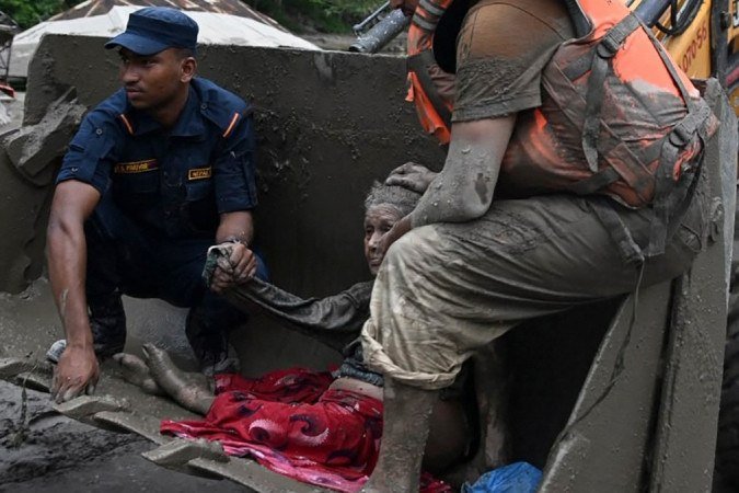 Equipes de resgate auxiliam uma vítima das inundações que devastaram a região fronteiriça do Nepal com o Tibete, onde centenas estão desaparecidas - (crédito: PRAKASH MATHEMA / AFP) Equipes de resgate auxiliam uma vítima das inundações que devastaram a região fronteiriça do Nepal com o Tibete, onde centenas estão desaparecidas - (crédito: PRAKASH MATHEMA / AFP)