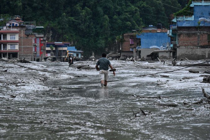 Morador local caminha em área devastada por enchentes causadas por um terremoto, em Devighat, no Nepal, nesta quarta-feira (26/8) - (crédito: AFP) Morador local caminha em área devastada por enchentes causadas por um terremoto, em Devighat, no Nepal, nesta quarta-feira (26/8) - (crédito: AFP)