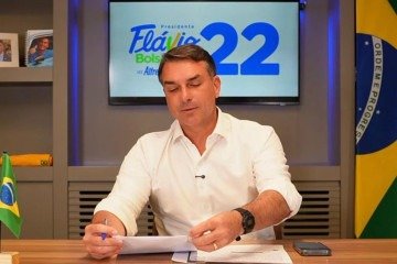 A semelhança também apareceu no visual: de camiseta branca e com uma caneta Bic na mão, e relógio Casio preto - (crédito: Reprodução/Flávio Bolsonaro/YouTube) A semelhança também apareceu no visual: de camiseta branca e com uma caneta Bic na mão, e relógio Casio preto - (crédito: Reprodução/Flávio Bolsonaro/YouTube)