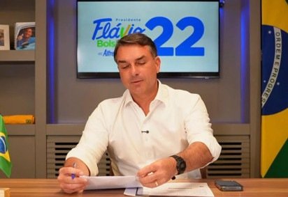 A semelhança também apareceu no visual: de camiseta branca e com uma caneta Bic na mão, e relógio Casio preto -  (crédito: Reprodução/Flávio Bolsonaro/YouTube) -A semelhança também apareceu no visual: de camiseta branca e com uma caneta Bic na mão, e relógio Casio preto -  (crédito: Reprodução/Flávio Bolsonaro/YouTube)