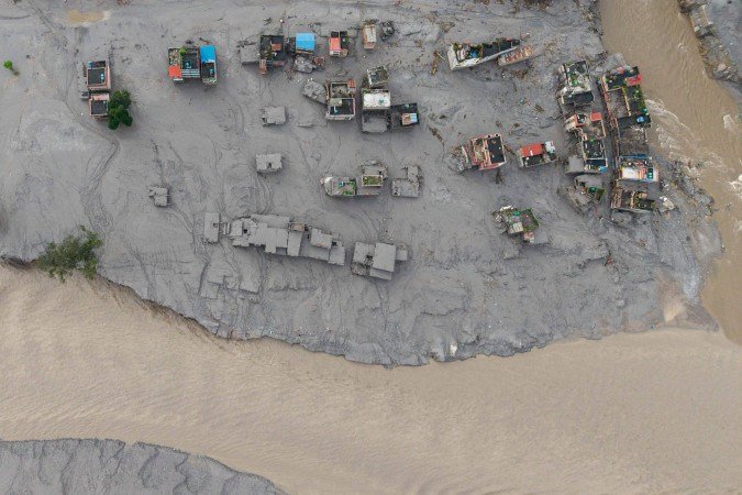 Imagem aérea mostra casas parcialmente submersas em Devighat, no encontro dos rios Bhote Koshi e Tadi, no distrito de Nukawot - (crédito: Prabin Ranabhat/AFP) Imagem aérea mostra casas parcialmente submersas em Devighat, no encontro dos rios Bhote Koshi e Tadi, no distrito de Nukawot - (crédito: Prabin Ranabhat/AFP)