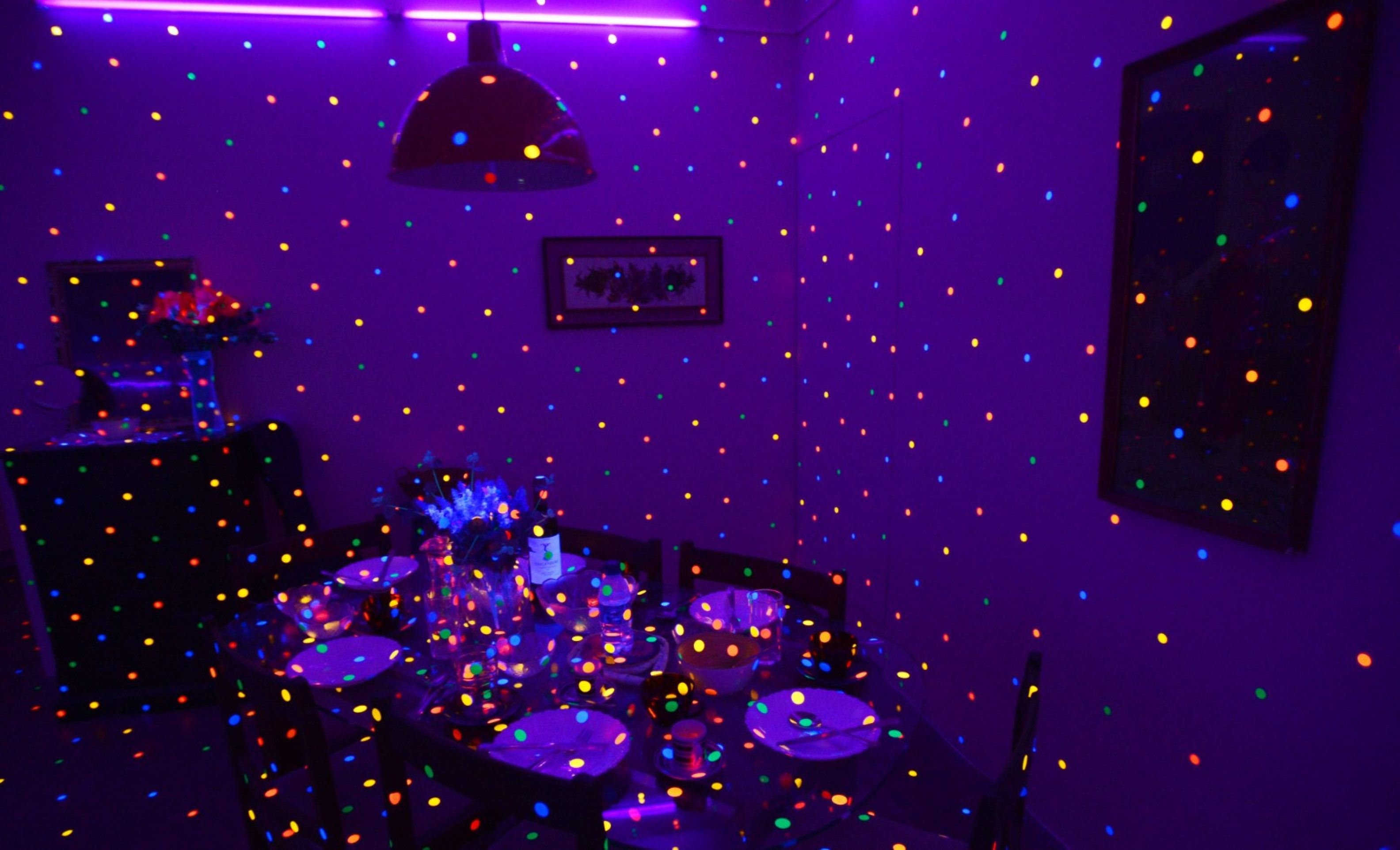 Uma das partes da exposi&ccedil;&atilde;o recria uma sala de estar comum coberta de pontos fluorescentes e brilhantes