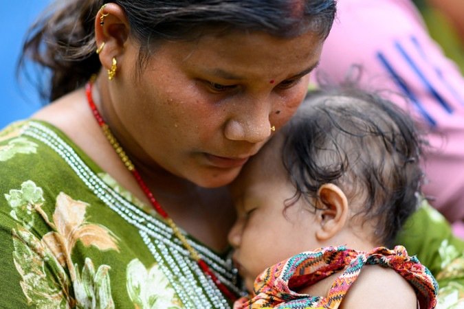 Mãe nepalesa aconchega filha de cinco meses na região de Nuwakot
