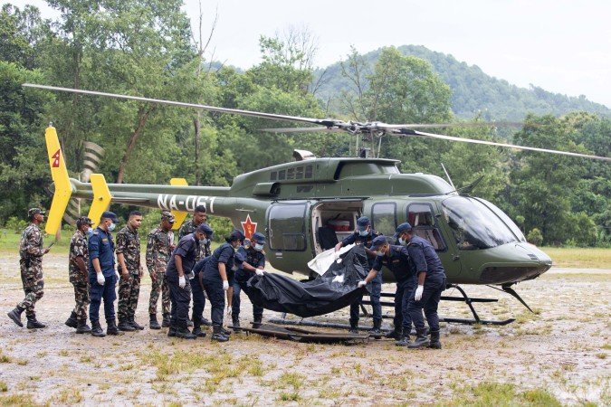 Soldados nepaleses retiram um corpo de helicóptero, em Trishuli