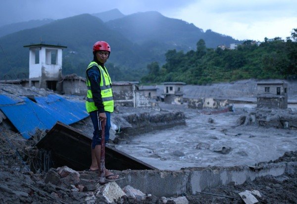 Socorrista observa prédios destruídos pela torrente de lama, em Trishuli Bazar, no distrito de Nuwakot: chuvas complicam operações de buscas  -  (crédito: Manan Vatsyayana/AFP)