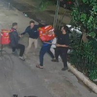 Cláudio é cercado pelos seguranças ilegais e entregadores, e é agredido. Ele não resistiu ao espancamento -  (crédito: Reprodução de vídeo)