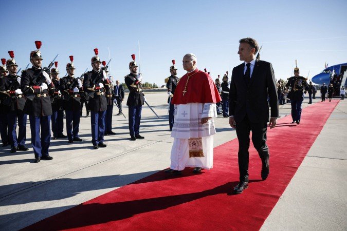 O Papa Leão XIV (à esquerda) e o presidente da França, Emmanuel Macron (à direita), inspecionam uma guarda de honra na pista após o desembarque do pontífice no aeroporto de Orly, nos arredores de Paris, em 25 de setembro de 2026, para uma visita de quatro dias à França. - (crédito: AFP) O Papa Leão XIV (à esquerda) e o presidente da França, Emmanuel Macron (à direita), inspecionam uma guarda de honra na pista após o desembarque do pontífice no aeroporto de Orly, nos arredores de Paris, em 25 de setembro de 2026, para uma visita de quatro dias à França. - (crédito: AFP)