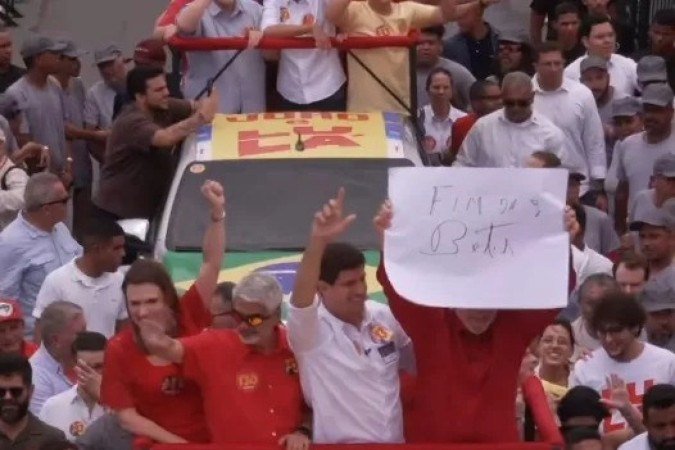 Lula segura cartaz com a frase 
