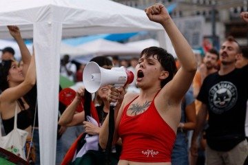 Faixa com os dizeres 'eles por dinheiro, nós por amor' - (crédito: EPA) Faixa com os dizeres 'eles por dinheiro, nós por amor' - (crédito: EPA)