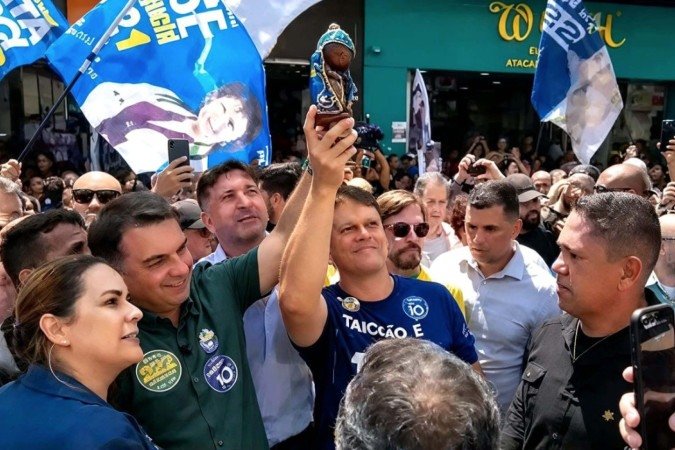 Flávio levanta imagem da santa em ato de campanha - (crédito: RS/Fotos Publicas) Flávio levanta imagem da santa em ato de campanha - (crédito: RS/Fotos Publicas)
