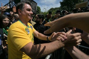 Brazil's right-wing senator and presidential candidate Flavio Bolsonaro of the Liberal Party (PL) greets supporters during a campaign rally on the eve of the general election, in Santa Barbara d'Oeste, state of Sao Paulo, Brazil on October 3, 2026. Brazilians go to the polls on October 4, 2026, in a tight race led by leftist President Luiz Inacio Lula da Silva and right-wing senator Flavio Bolsonaro, son of former president Jair Bolsonaro, who is serving house arrest. (Photo by NELSON ALMEIDA / AFP)
Caption - (crédito: AFP) Brazil's right-wing senator and presidential candidate Flavio Bolsonaro of the Liberal Party (PL) greets supporters during a campaign rally on the eve of the general election, in Santa Barbara d'Oeste, state of Sao Paulo, Brazil on October 3, 2026. Brazilians go to the polls on October 4, 2026, in a tight race led by leftist President Luiz Inacio Lula da Silva and right-wing senator Flavio Bolsonaro, son of former president Jair Bolsonaro, who is serving house arrest. (Photo by NELSON ALMEIDA / AFP)
Caption - (crédito: AFP)