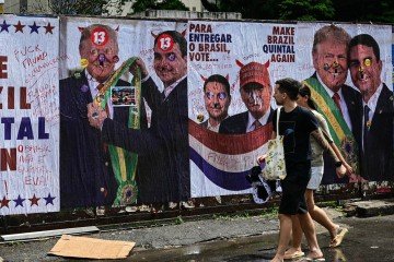 Muro com críticas alusivas à relação entre Donald Trump e Flávio Bolsonaro, em São Paulo - (crédito: Pablo Porciuncula/AFP) Muro com críticas alusivas à relação entre Donald Trump e Flávio Bolsonaro, em São Paulo - (crédito: Pablo Porciuncula/AFP)
