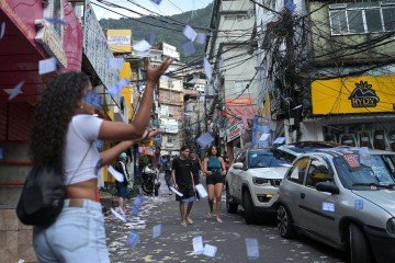 Ações de campanha com panfletos políticos marcam as ruas da Rocinha, refletindo o cenário eleitoral da comunidade - (crédito: Tercio Teixeira/AFP) Ações de campanha com panfletos políticos marcam as ruas da Rocinha, refletindo o cenário eleitoral da comunidade - (crédito: Tercio Teixeira/AFP)