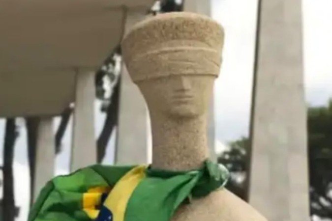 Estátua da Justiça pichada com a mensagem 