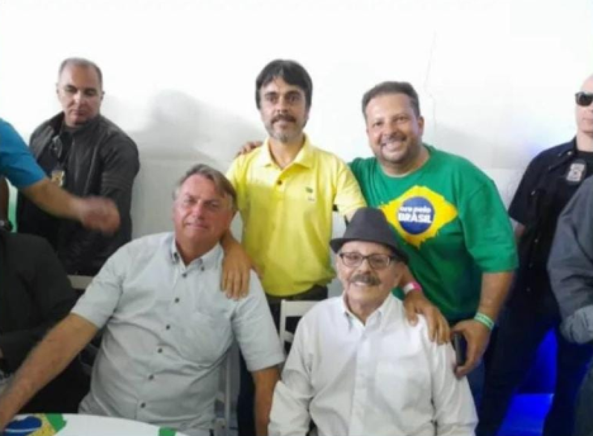 Foto usada na peça de desinformação mostra Bolsonaro sentado ao lado de Goes. De pé, vestido de amarelo, é Giovani Goes. Joctã Barros está vestindo camisa verde