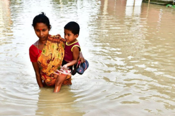Família tenta escapar de enchente na Índia; fundo de perdas e danos coloca em questão participação do país e da China  -  (crédito: Getty Images)