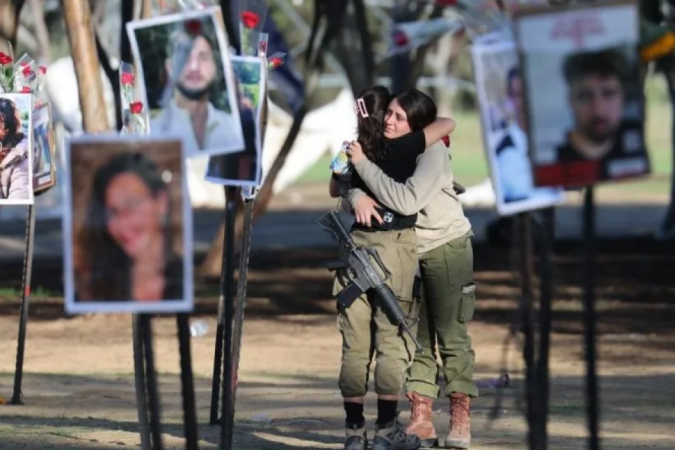 Soldados israelenses se abraçam enquanto olham fotos das vítimas do festival dos ataques de 7 de outubro - (crédito: EPA) Soldados israelenses se abraçam enquanto olham fotos das vítimas do festival dos ataques de 7 de outubro - (crédito: EPA)