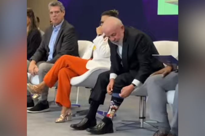 Lula arrumando meia com rosto de Frida Kahlo durante 12ª Conferência Nacional dos Direitos da Criança e do Adolescente.