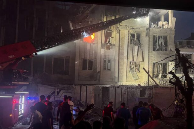 Espectadores e equipes de resgate em frente a um prédio vitimado pelo fogo depois de um ataque israelense, nesta sexta-feira (13/6), em Teerã, capital do Irã - (crédito: Sepah News / AFP) Espectadores e equipes de resgate em frente a um prédio vitimado pelo fogo depois de um ataque israelense, nesta sexta-feira (13/6), em Teerã, capital do Irã - (crédito: Sepah News / AFP)