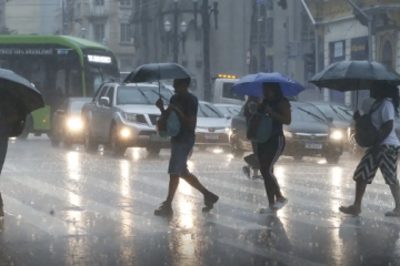 Cidadão paulistanos se protegem da chuva no centro da cidade de São Paulo, nesta quinta-feira (8/1) -  (crédito: Paulo Pinto / Agência Brasil)